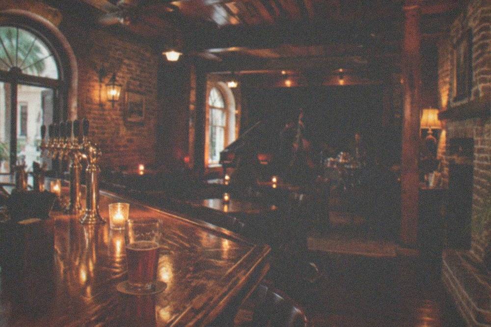 A candlelit pub interior with weathered wooden beams