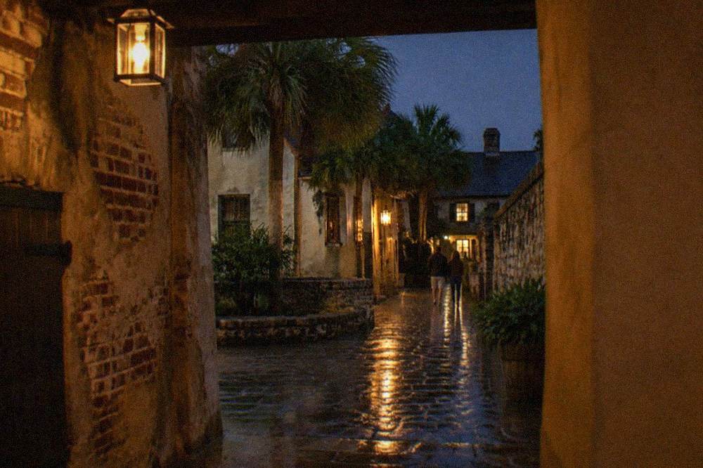A narrow colonial-era street in St. Augustine lit by lanterns after dark