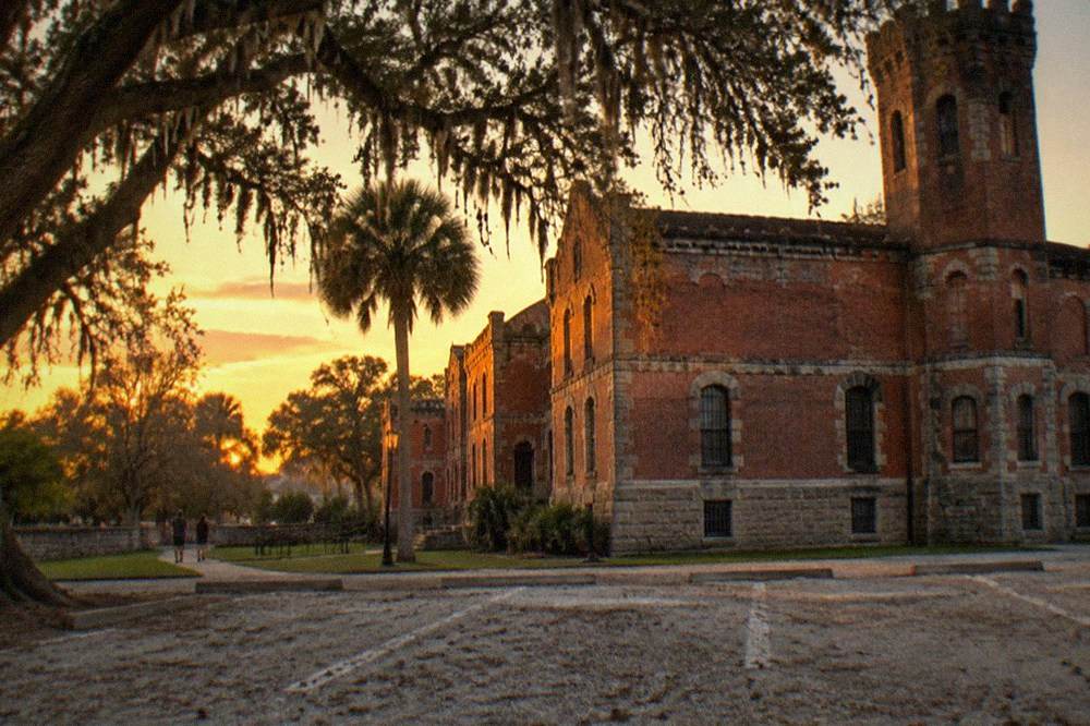 The red brick exterior of the Old Jail with its tower under an evening sky